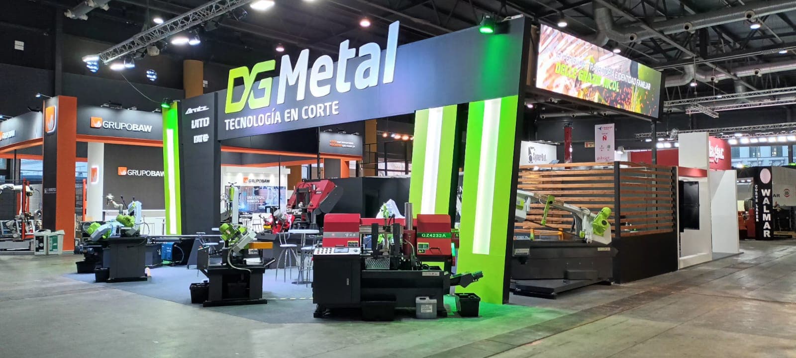 Stand de DG Metal exhibiendo maquinaria industrial para corte de metales en una feria.