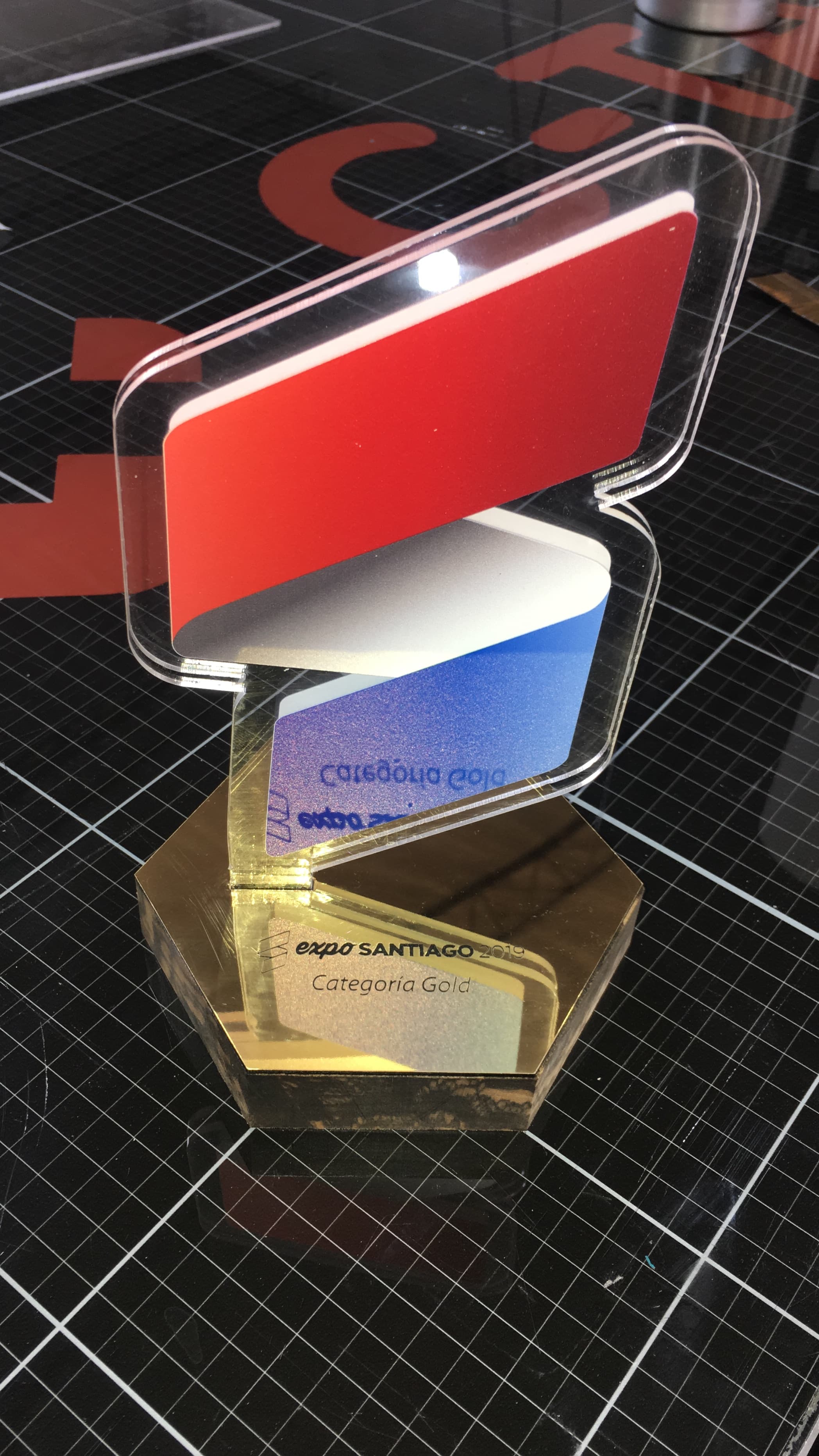Trofeo de acrílico tricolor con base dorada grabado Expo Santiago 2019 Categoría Gold.